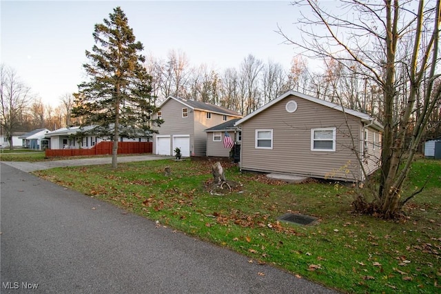 5192 University Dr, Geneva, OH 44041 - view of front of home featuring driveway, a garage, and a front lawn
