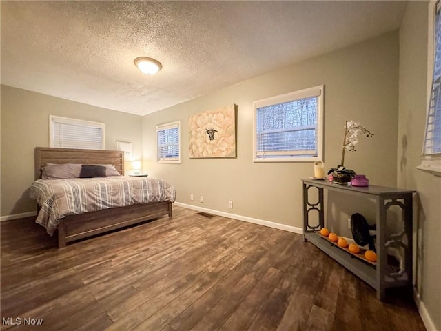 5192 University Dr, Geneva, OH 44041 - bedroom with a textured ceiling, dark wood finished floors, visible vents, and baseboards