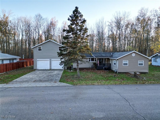 5192 University Dr, Geneva, OH 44041 - view of front of house featuring a garage, driveway, a front lawn, and fence