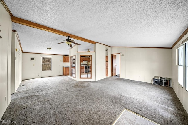 unfurnished living room with carpet floors, lofted ceiling with beams, ornamental molding, and a textured ceiling