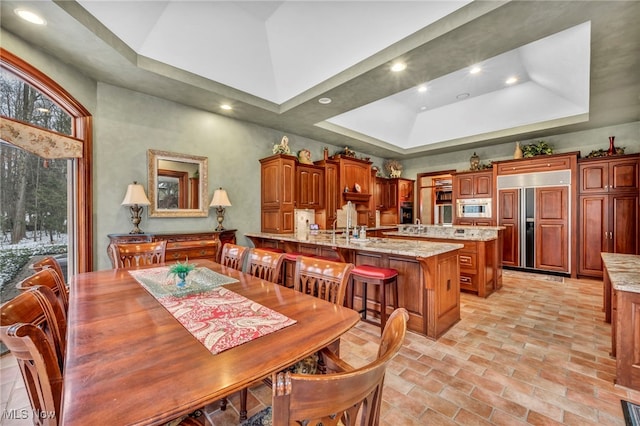 dining area featuring a tray ceiling, recessed lighting, and a towering ceiling