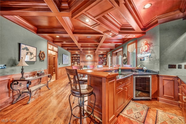 bar featuring wine cooler, ornamental molding, indoor wet bar, coffered ceiling, and a sink