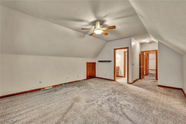 additional living space with carpet flooring, a ceiling fan, lofted ceiling, and baseboards