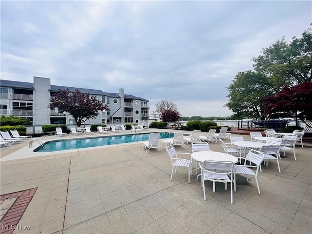 community pool featuring a patio area and fence