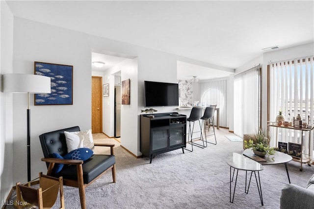 living room with light colored carpet, a wealth of natural light, and visible vents