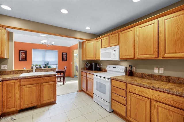 kitchen featuring white appliances, an inviting chandelier, a sink, and recessed lighting