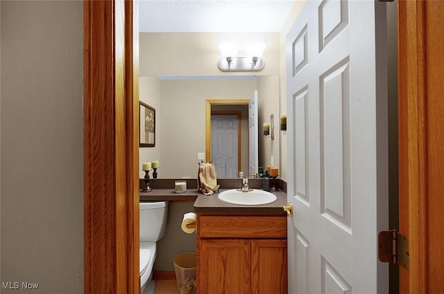 half bathroom with vanity and toilet