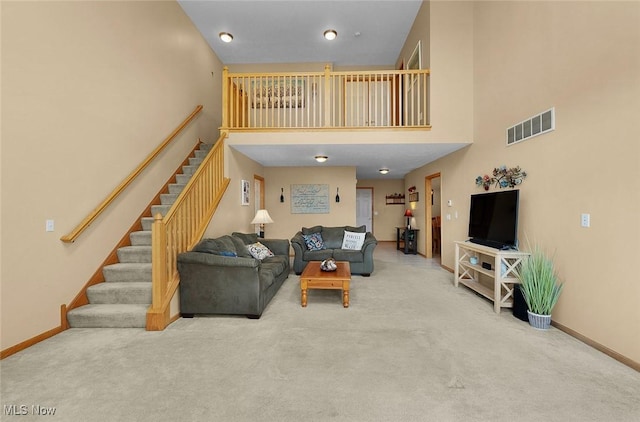 living room with carpet floors, visible vents, and baseboards