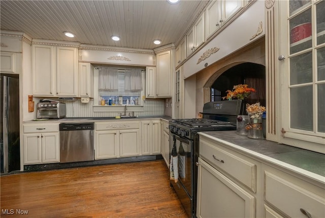 kitchen with dark wood-type flooring, a sink, stainless steel dishwasher, black range with gas stovetop, and freestanding refrigerator