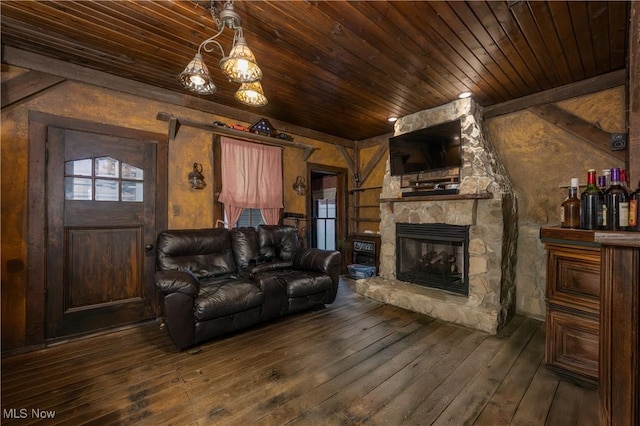 living area with wooden ceiling, hardwood / wood-style floors, and a stone fireplace