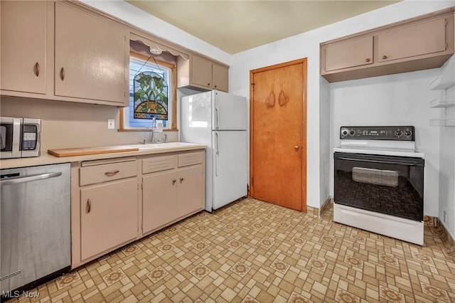 kitchen featuring appliances with stainless steel finishes, light countertops, and a sink