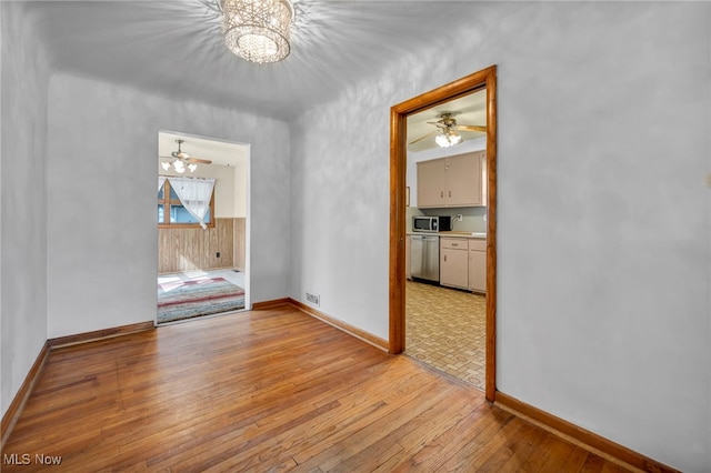 empty room featuring light wood-type flooring, baseboards, and visible vents