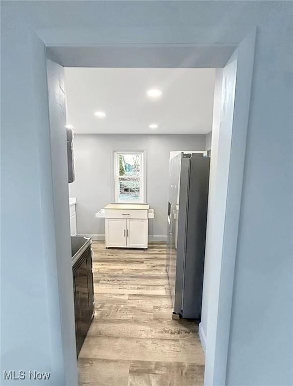 bathroom with baseboards, wood finished floors, and recessed lighting