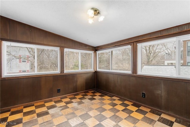 unfurnished sunroom featuring lofted ceiling and a wealth of natural light