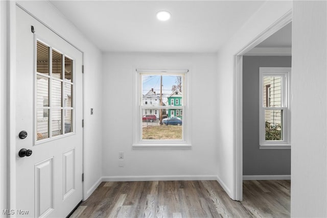 doorway to outside with baseboards and wood finished floors