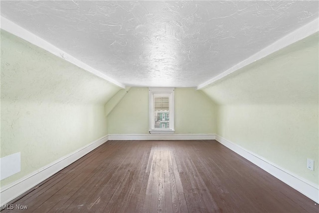 bonus room with lofted ceiling, baseboards, a textured ceiling, and hardwood / wood-style floors