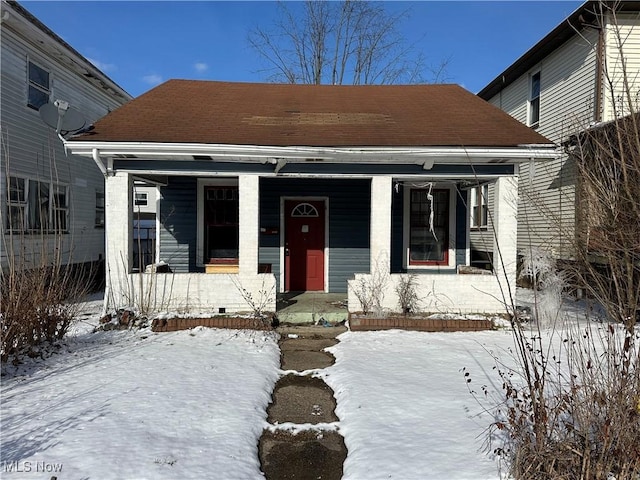 bungalow-style home with a shingled roof and a porch