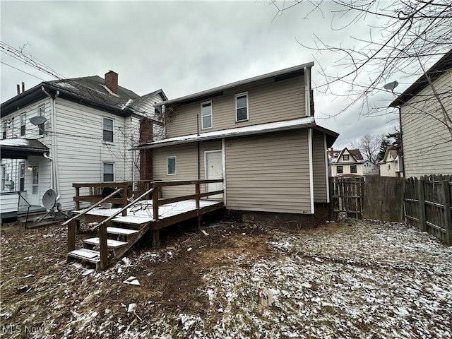 rear view of house with a deck and fence