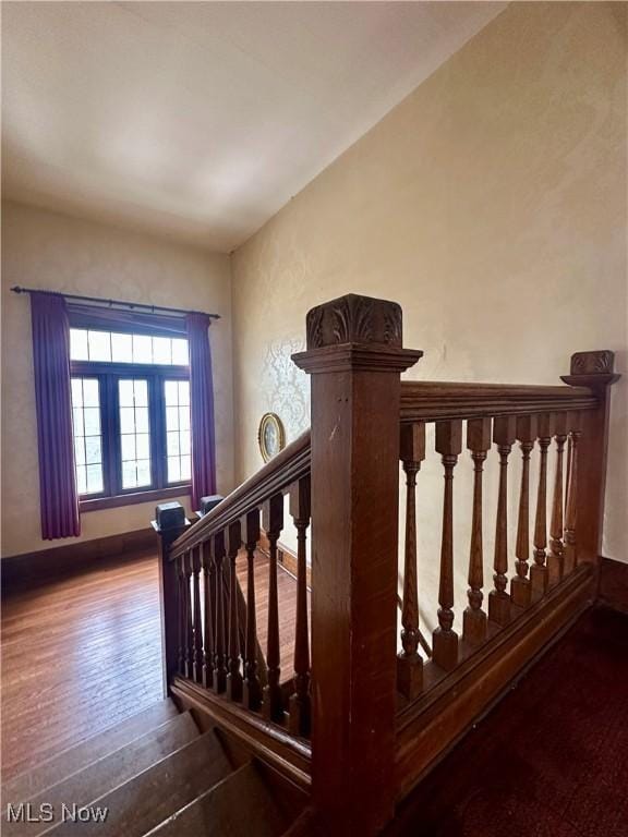 staircase featuring wood-type flooring and baseboards