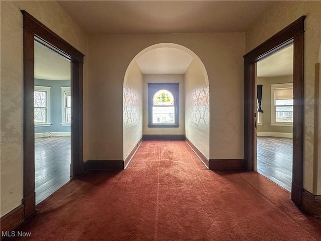 hallway featuring carpet floors and baseboards