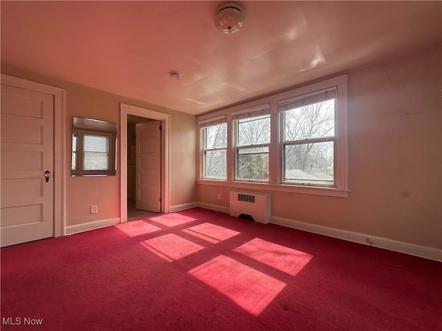 unfurnished room featuring radiator, baseboards, and carpet flooring