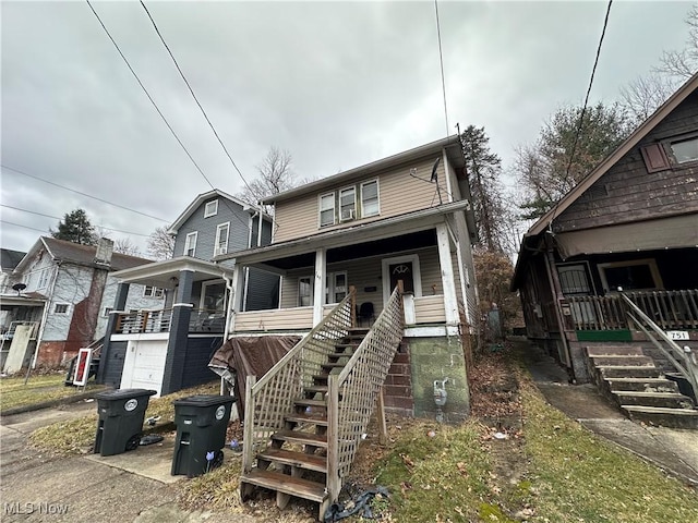 view of front of house featuring a porch, a garage, and stairs