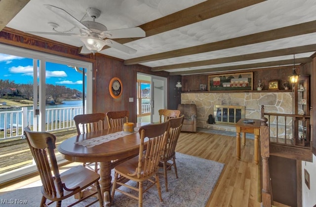 382 E Mohawk Dr, Malvern, OH 44644 - dining space with beamed ceiling, a fireplace, wooden walls, a ceiling fan, and light wood finished floors