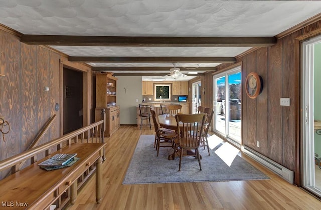 382 E Mohawk Dr, Malvern, OH 44644 - dining space featuring a baseboard radiator, light wood-style flooring, wood walls, a ceiling fan, and beam ceiling