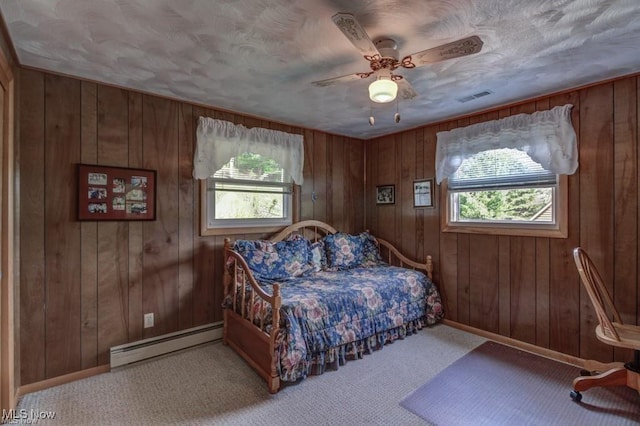 382 E Mohawk Dr, Malvern, OH 44644 - bedroom featuring a baseboard heating unit, multiple windows, wooden walls, carpet, and baseboards