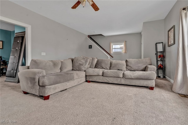 living room with carpet, a ceiling fan, and baseboards