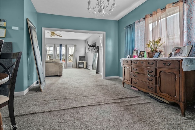 corridor with baseboards, carpet floors, and an inviting chandelier