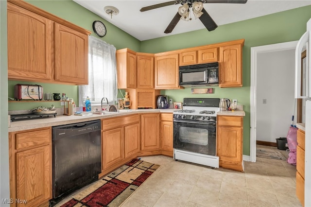 kitchen featuring black appliances, a ceiling fan, light countertops, and a sink