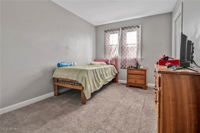 bedroom featuring light carpet and baseboards