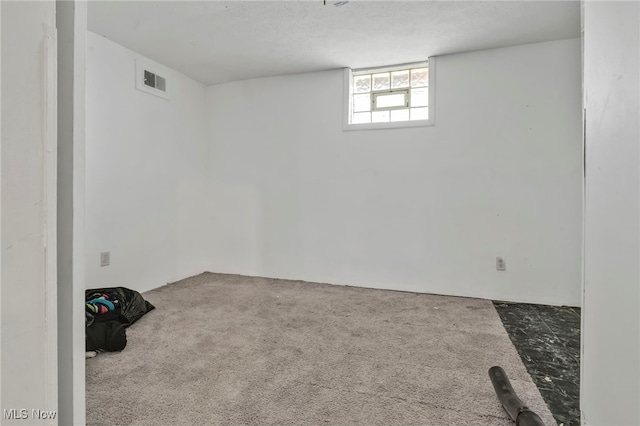 basement featuring carpet flooring and visible vents