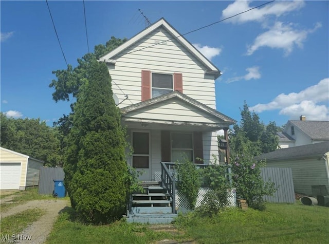 view of front of home featuring covered porch, driveway, and a detached garage