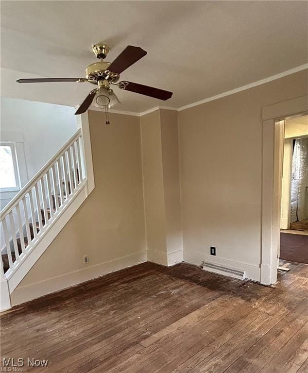 unfurnished room featuring wood-type flooring, visible vents, crown molding, and stairs