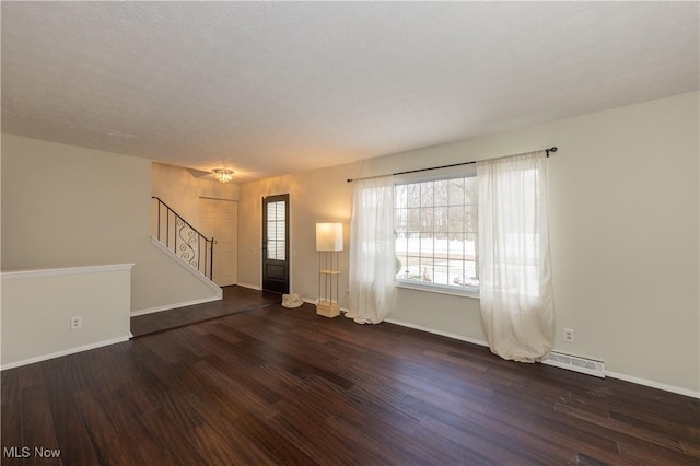 unfurnished living room with baseboards, stairs, visible vents, and wood finished floors