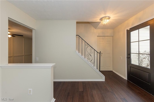 entrance foyer with a ceiling fan, stairs, baseboards, and dark wood-style flooring