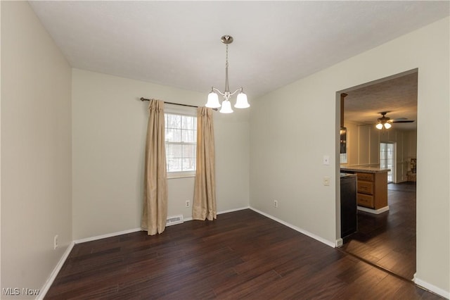 spare room featuring baseboards, visible vents, dark wood-style flooring, and ceiling fan with notable chandelier