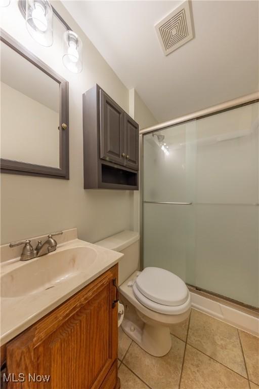 full bath with toilet, tile patterned flooring, visible vents, and a shower stall