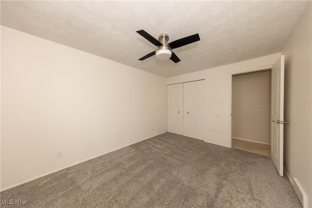 unfurnished bedroom with a ceiling fan, a closet, carpet flooring, and a textured ceiling