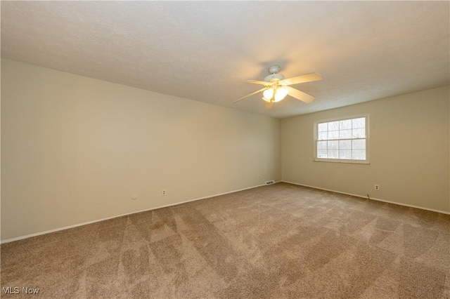 carpeted empty room featuring a ceiling fan