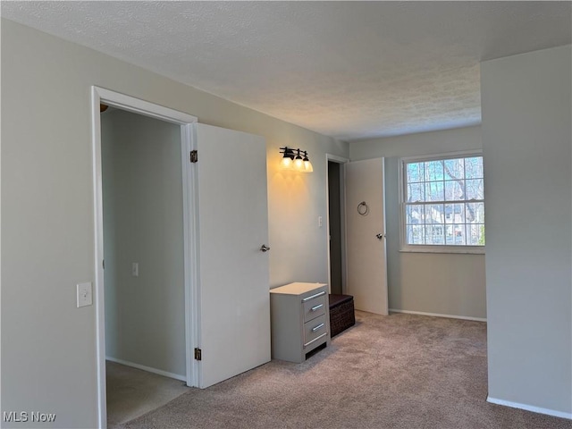 unfurnished bedroom with light carpet and a textured ceiling