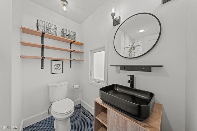 bathroom featuring vanity, toilet, and baseboards