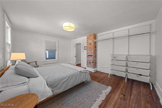 bedroom with a closet, wood-type flooring, and baseboards