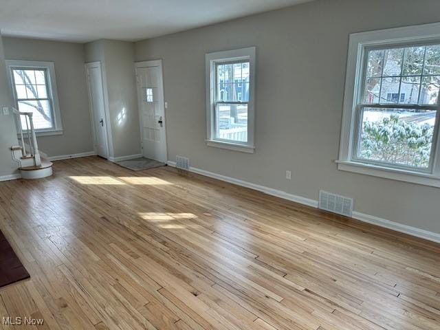 foyer featuring light wood-style flooring, visible vents, and baseboards