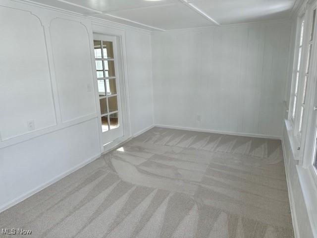 carpeted empty room featuring a decorative wall