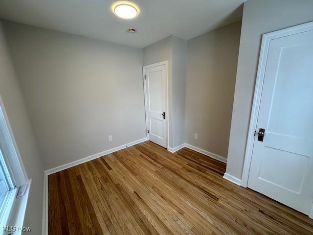 unfurnished bedroom featuring wood finished floors and baseboards