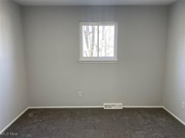 carpeted spare room featuring visible vents and baseboards