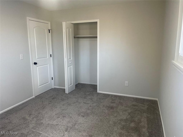 unfurnished bedroom with carpet floors, a closet, and baseboards